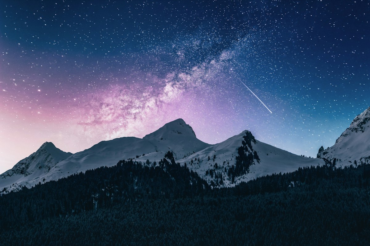 A snowy mountain under a star-filled sky
